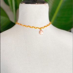 A handmade necklace with a pink stone.